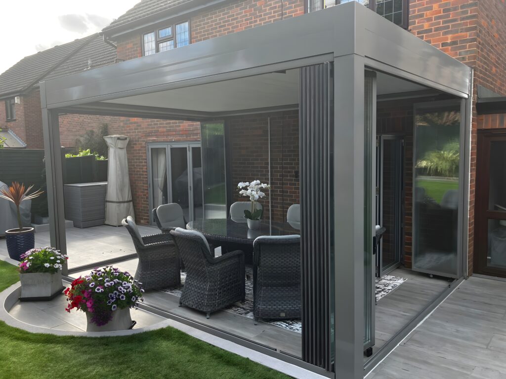 Bir evin bahçesinde kurulumu tamamlanmış katlanır cam sistemi